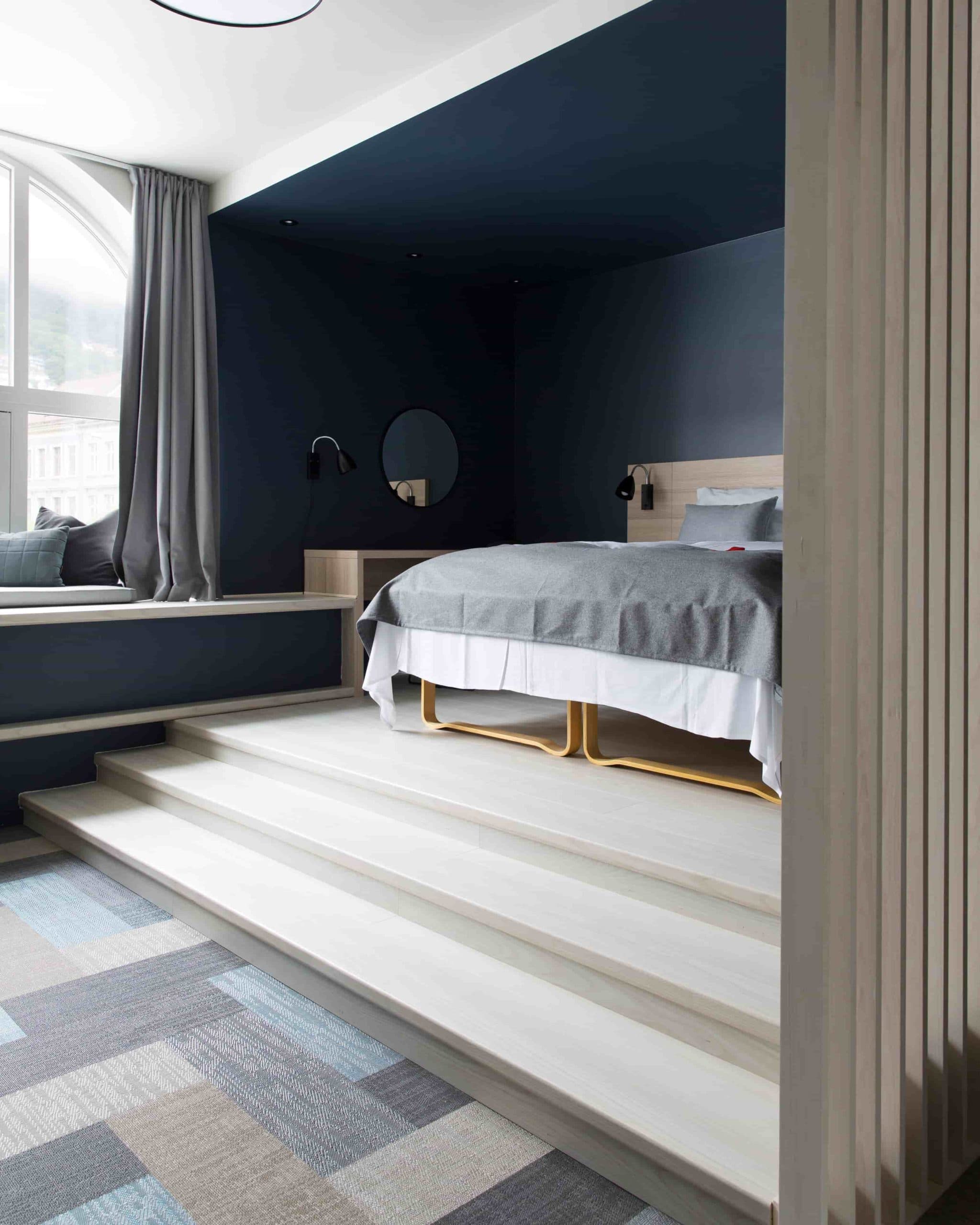 Picture of the junior suite in Bergen, where there is a small stair up to the bed